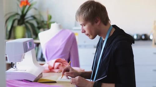 Créateur de mode avec dessin de cahier au studio