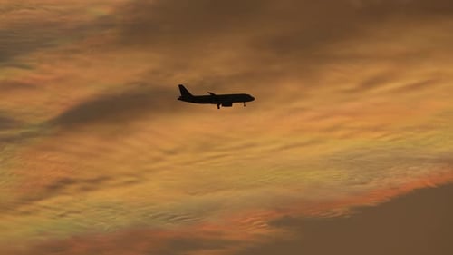Silhoutte d'un avion survolant le ciel couchant