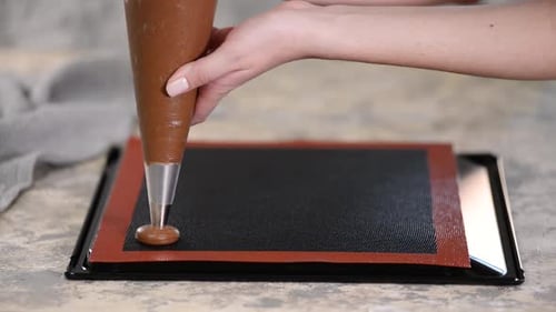 Cooking Chocolate Profiteroles, Female Hands Squeeze the Dough From the Bag Onto Baking Sheet.