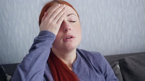 Sick Woman Sneezes Into a Paper Scarf at Home.