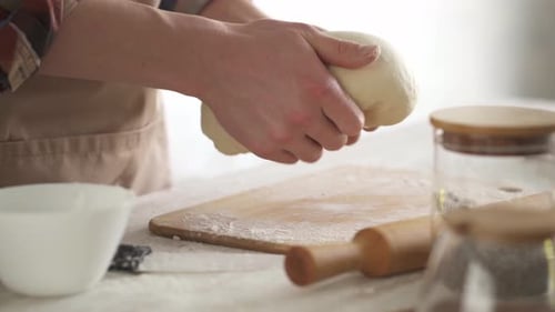 Kneading Fresh Cream Colored Dough To Make Homemade French Bread.