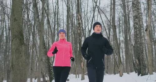 A Beautiful Woman and a Man Are Running in the Forest in Winter Proper Nutrition and a Healthy