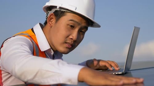 Young technician man working on laptop in solar farm