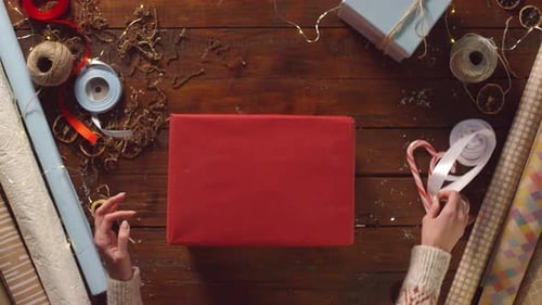 Wrapping Christmas Present with Ribbon and Candy Cane