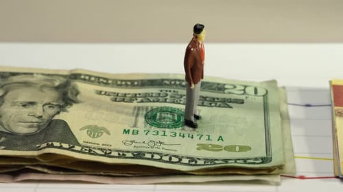 Figures Stand on US Dollars and Mexican Peso Notes
