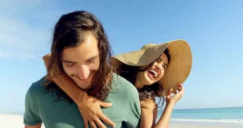 Happy Couple Piggyback Ride on a Sunny Beach