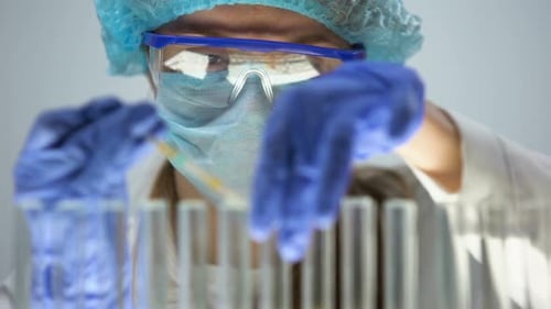 Chimiste vérifiant le niveau d'acidité dans le liquide d'essai bleu avec du papier de tournesol, contrôle