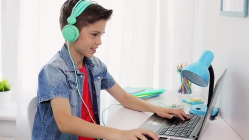 Junge im Kopfhörer spielt Videospiel auf Laptop