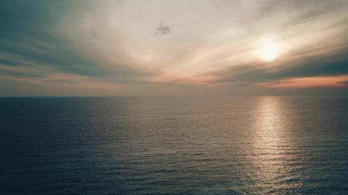Puesta de sol sobre el mar, nubes oscuras