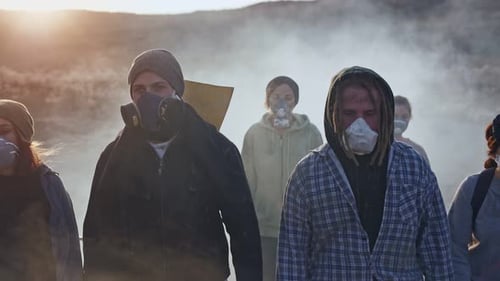 Gruppe junger Leute in Gasmaske geht durch den giftigen Rauch nach unten