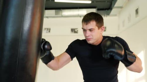 MMA Fighter Boxers Doing Some Training on a Punching Bag at a Gym Close Up Power Punch Kicks Macro