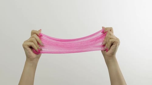 Woman Hands Playing Oddly Satisfying Pink Slime on White Background. Antistress