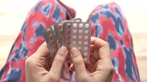 Women Hand Golding Birth Control Pills Close Up