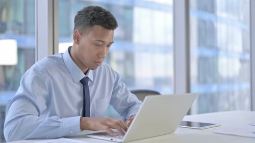 Afroamerikanischer Geschäftsmann arbeitet am Laptop