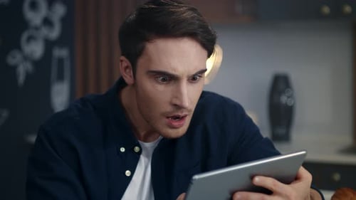 Focused Businessman Reading Project Results on Tablet Computer at Home Office