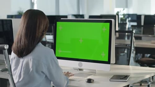 Business Multiethnic Woman Working on Desktop Computer with Green Screen Mock Up Display in Busy