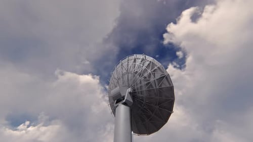 Rotating Satellite Dish Antenna Under Cloudy Sky