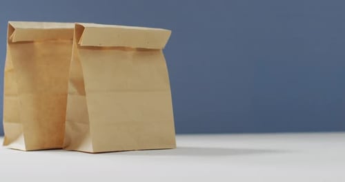 Animación de bolsas de almuerzo de papel sobre fondo azul