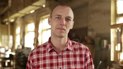 Man Wearing Plaid Shirt Standing in a Workshop