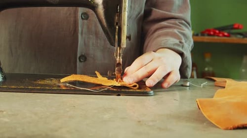 A Tailor in the Workshop Makes an Exclusive Bag Made of Genuine Leather Using a Sewing Machine