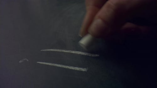 Hand Writing the Word Idea on Blackboard