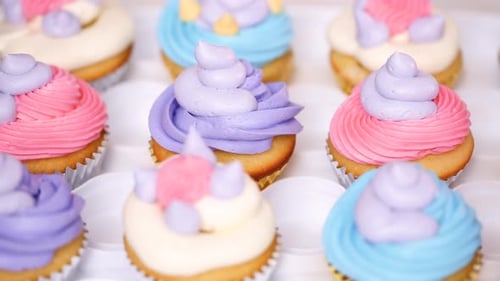 Schritt für Schritt. Konditorin spritzt Buttercreme-Zuckerguss auf Einhorn-Cupcakes zum Geburtstag eines kleinen Mädchens