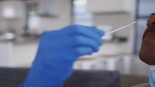 Medical Professional Administering Nasal Swab Test Indoors