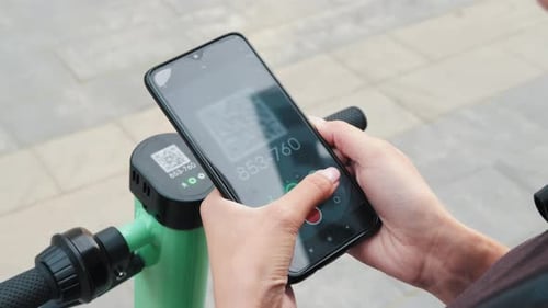 Using Phone Near Electric Scooter in Urban Setting