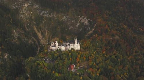AERIAL: View of Neuschwanstein Castle in Forest,Mountains, Summer, Foggy, Colourful