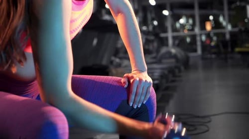 Woman Lifting Dumbbell in Fitness Center Gym