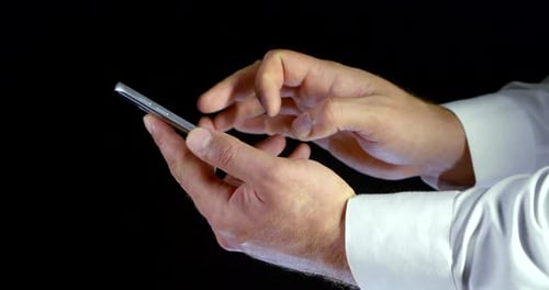 Nahaufnahme von männlichen Händen im weißen Hemd Elektronisch Gadget-Telefon mit Touchscreen-Scrolling und