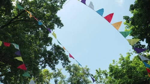 Festive Bunting Flags Hanging Amongst Green Summer Trees