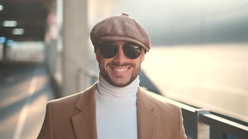 Glücklicher erfolgreicher Geschäftsmann schaut in die Kamera und lächelt. Lustiges Straßenporträt von Joyful