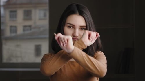 Young Woman Gesturing No and Talking Indoors