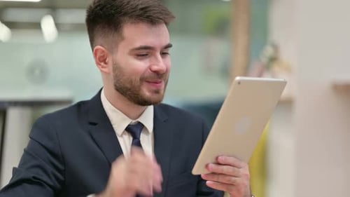 Young Adult on Video Call With Tablet in Office