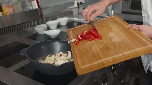 Chef Adds Vegetables to Pan on Stove