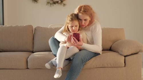 Mother and Daughter Enjoying Phone at Home
