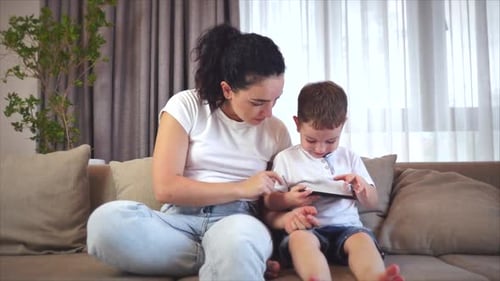 Woman and Child Watch Phone Together at Home