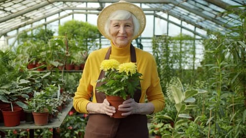 Senior Woman Holding Flowers in Greenhouse