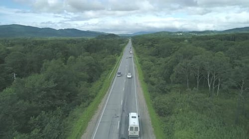 Aerial View Above Cars Driving Along Empty Countryside Road on Sunny Day