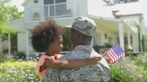 Child Hugs Military Father With American Flag