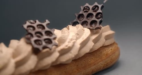 Confectioner Finishes Eclair with Pieces of Chocolate and Puts Them on Cream By Small Tweezer