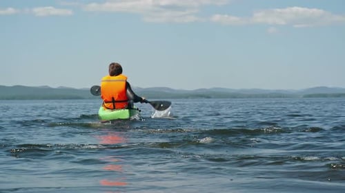 Kayaker Paddling on Lake on Sunny Day