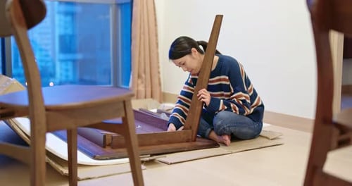 Woman Assembling Wood Table Indoors at Home