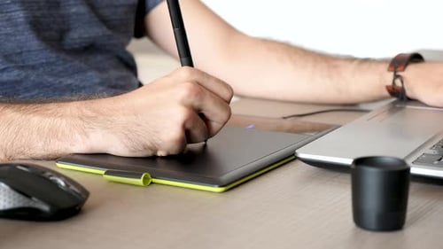 Adult Using Graphics Tablet at Desk Close Up