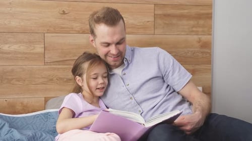 Father and Daughter Reading a Book Together