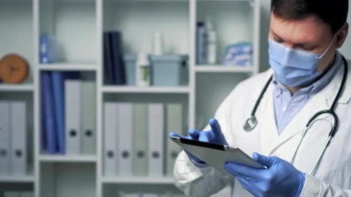 Le médecin touche la tablette protectrice. Il regarde la tablette, agrandit l'image et tape