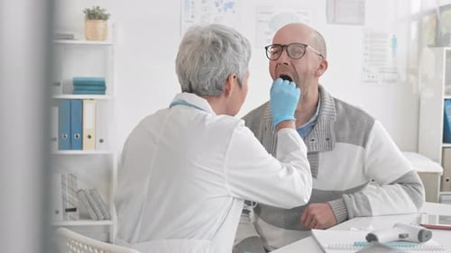 Doctor Examines Patient's Throat in Office