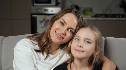Woman and Child Smiling and Embracing on Sofa