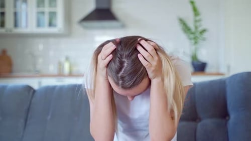 Verzweifelte hübsche junge Frau mit Händen auf dem Kopf